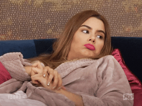 A woman reclines on a couch looking doubtful.