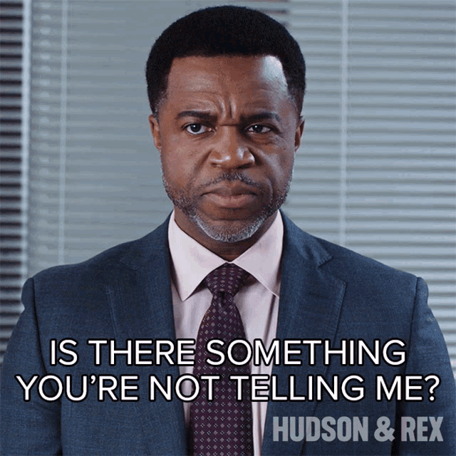 a picture of a man in a suit and tie with the caption is there something you 're not telling me