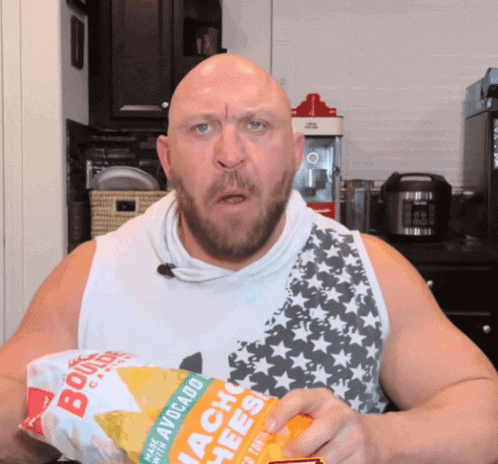 a man holding a bag of avocado nacho cheese chips