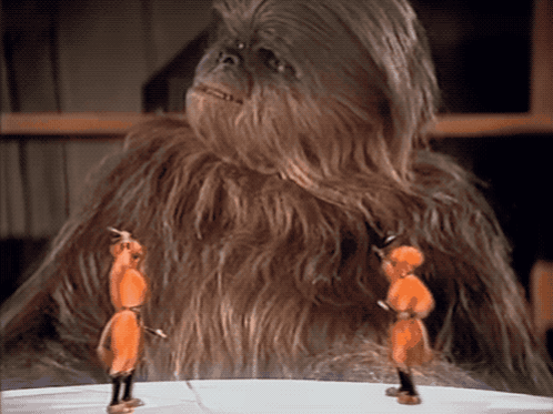 a close up of a chewbacca standing next to two soldiers on a table