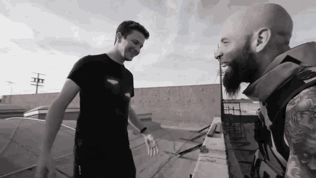 two men are standing next to each other and one has a beard