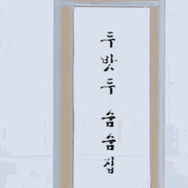 a man in a suit is standing in a doorway with a foreign language written on it .