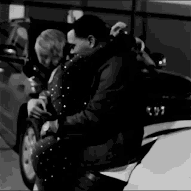 a black and white photo of a man and woman hugging