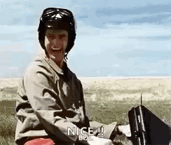 A man in a helmet awkwardly misses a high five.