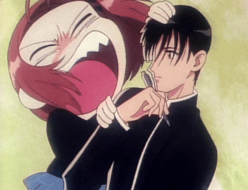 An anime girl screams while grabbing a startled boy's face.