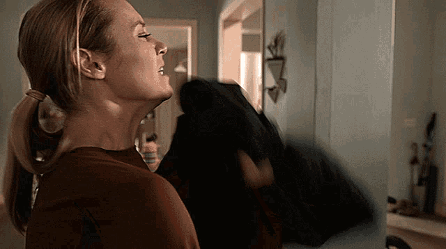 a woman in a red shirt is looking up at something
