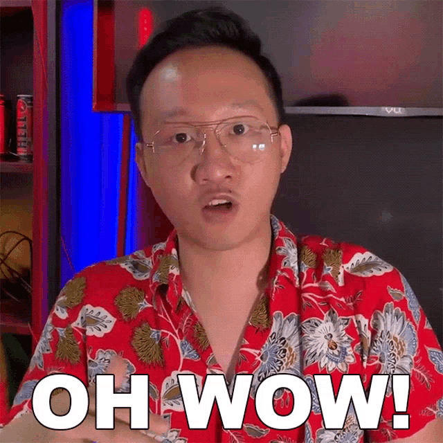 a man wearing glasses and a red shirt is saying oh wow