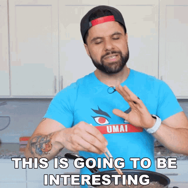 a man in a blue shirt that says umai is cooking something