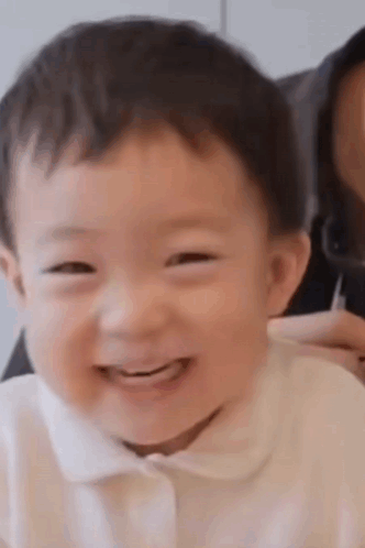A smiling baby looks toward the camera.