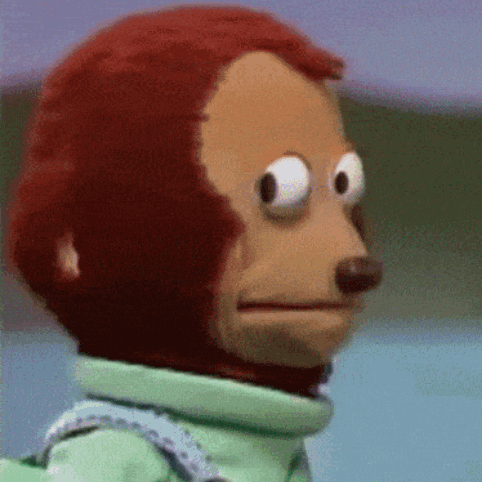 A monkey puppet turns away with an awkward sideways glance.