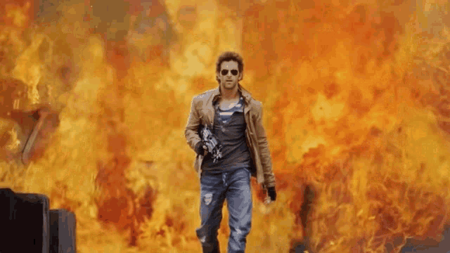 a man holding a gun is running from a fire