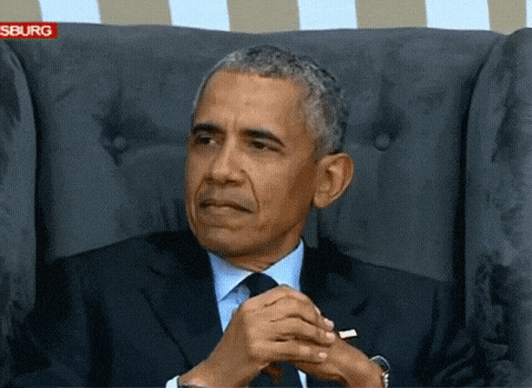 Barack Obama sits back with clasped hands and a skeptical look.