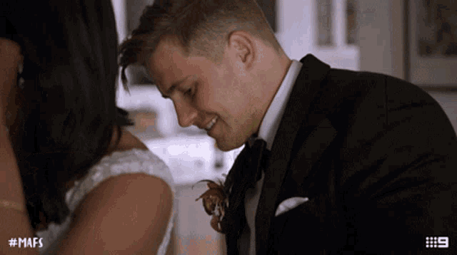 a man in a tuxedo is kissing a woman 's neck with the hashtag # mafs on the bottom