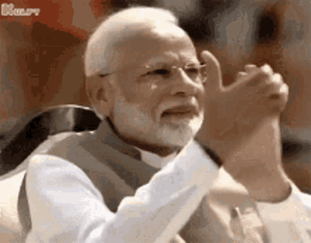 Narendra Modi claps alone with a serious expression.