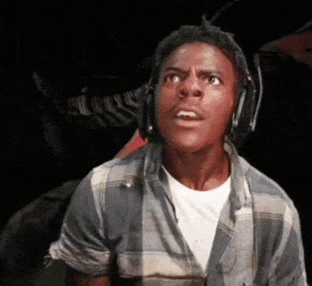 A person in headphones stares ahead with a shocked, energized expression.