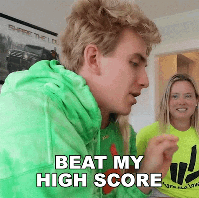 a man wearing a green hoodie says " beat my high score "