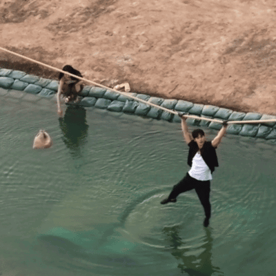 a man is hanging over a body of water