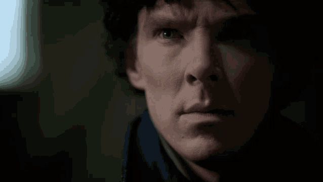 a close up of a man 's face with a blue shirt on