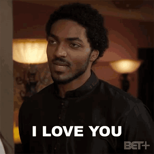 a man with a beard is saying `` i love you '' in a room .