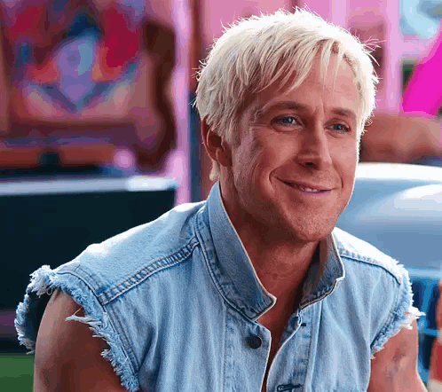 Ken smiles brightly in a sleeveless denim vest.