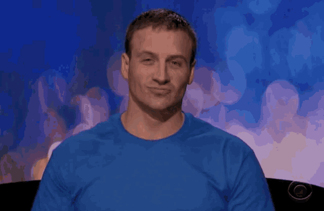 a man wearing a blue shirt is making a face