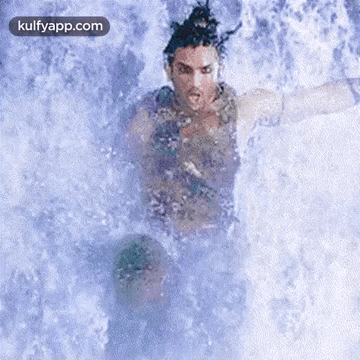 a man is swimming in a waterfall with the words kulfyapp.com written on the bottom