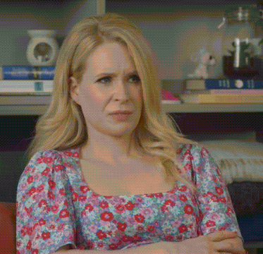 Lucy Beaumont sits with folded arms and an unimpressed, uncomfortable expression.