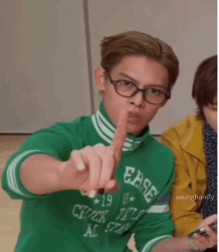 a young man wearing glasses and a green shirt that says ease on it