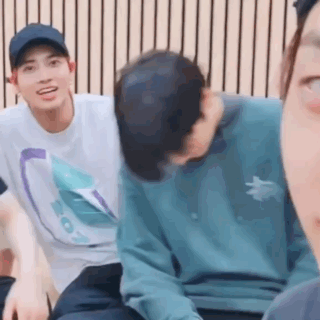 a group of young men are sitting next to each other and laughing .