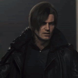 a man in a black jacket is standing in front of a white object .