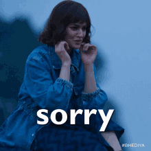 A woman looks distressed while “sorry” appears in white text.