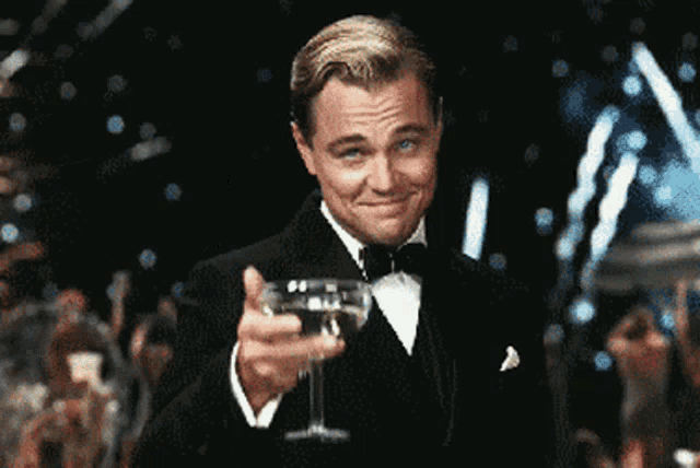 Leonardo DiCaprio raises a champagne glass in a formal toast from The Great Gatsby.