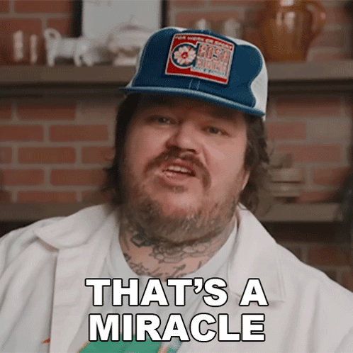 a man with a beard wearing a blue and white hat says that 's a miracle