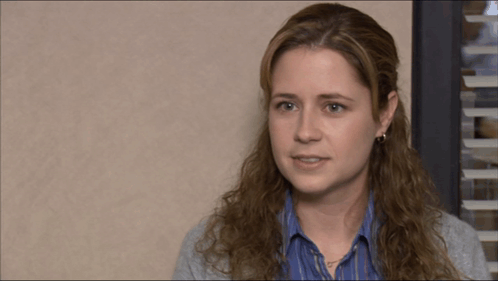 Pam Beesly looks teary and subdued in an office scene.
