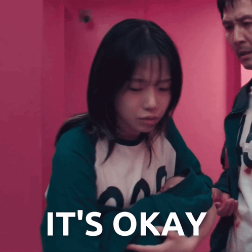 a woman is being held by a man with the words it 's okay written on the bottom