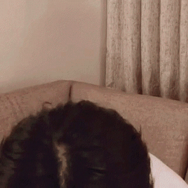 a person is laying on a couch with their eyes closed .