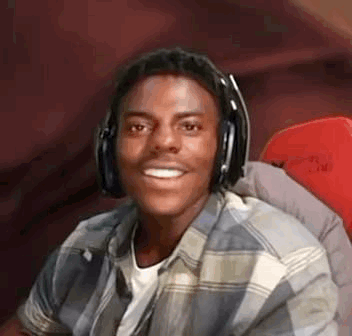 A headset-wearing streamer smiles in astonished delight.