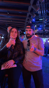 a man and a woman pose for a picture in a dark room