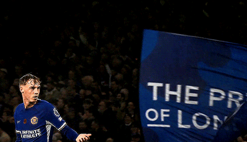 a soccer player in a blue jersey holds a flag that says the pride of london