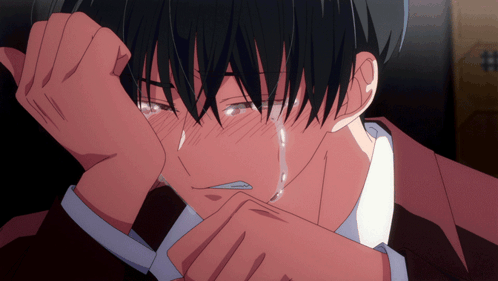 An anime boy leans on his arm while crying hard.