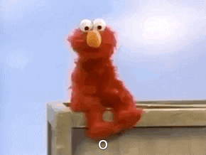 Elmo sits on a ledge looking embarrassed.