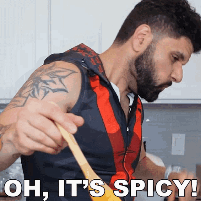 a man is stirring something with a wooden spoon and the words oh it 's spicy above him