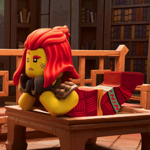 a lego figure with red hair is sitting on a table