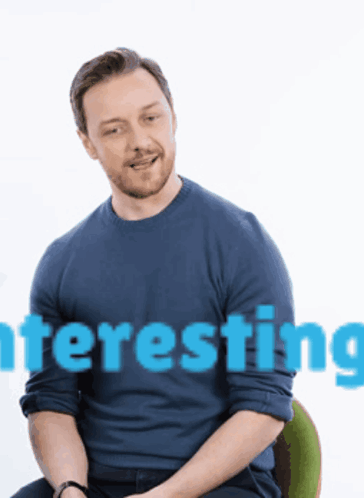 a man in a blue shirt is sitting in front of a white background with the word interesting on it