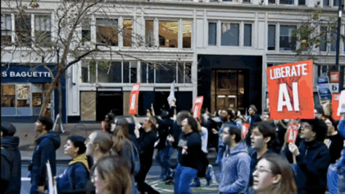 a group of people marching down a street holding a sign that says liberate ai