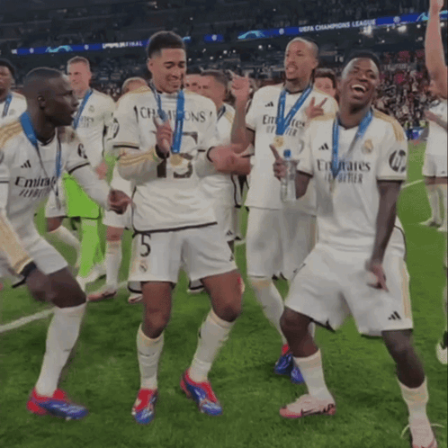 a group of soccer players wearing emirates jerseys celebrate on the field