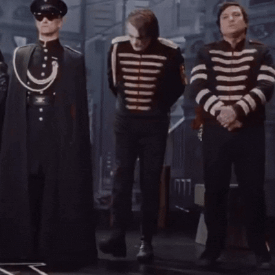 a man in a black and white striped jacket stands between two other men