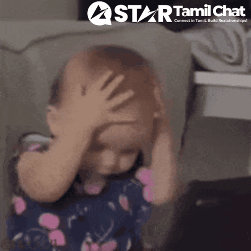 A toddler covers their face with one hand in a distressed reaction.