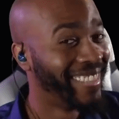 A bald man raises his eyebrows and smiles knowingly.