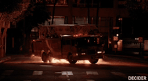 a van is driving down a street at night with the word decider below it